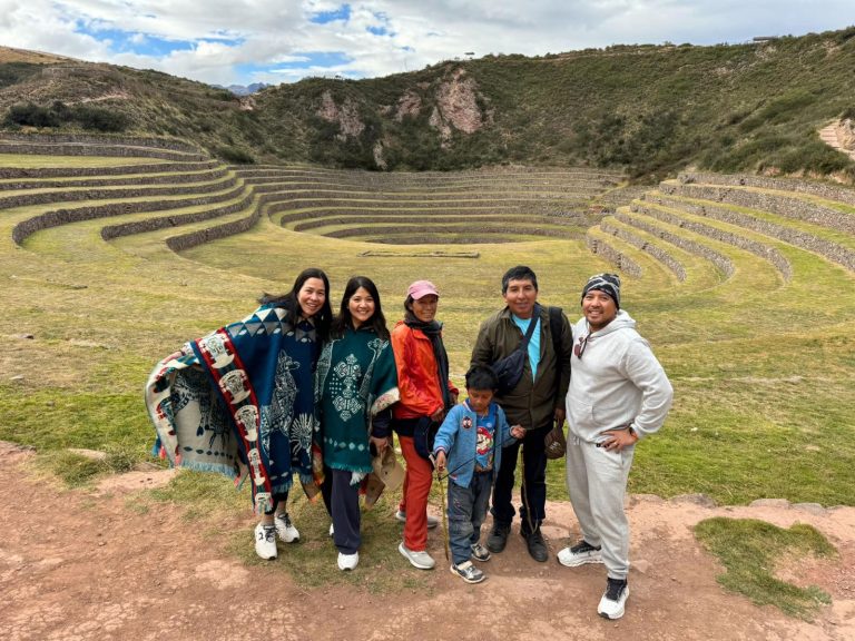 Turistas recorriendo las terrazas circulares de Moray durante el Tour Valle Sagrado VIP desde Cusco.